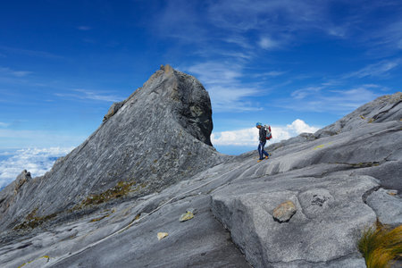 RANAU, MALAYSIA - AUGUST 23, 2014 - Climbers walk down the Low's Peak (4095m) across the St. John Peak (4090m) of Mount Kinabalu, Sabah, Malaysia. Mount Kinabalu or Gunung Kinabalu is the 20th most prominent mountain in the world by topographic prominenceのeditorial素材