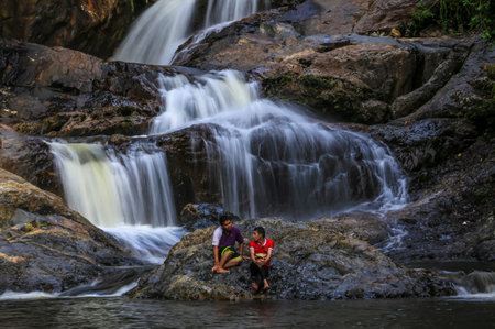 KENYIR LAKE, MALAYSIA - AUGUST 27, 2016 : Tourist enjoy the beautiful of Lasir waterfall, Kenyir Lake, Terengganu. Lasir waterfall also known as Air Terjun Lasir.のeditorial素材
