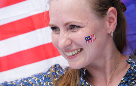 KUALA LUMPUR, MALAYSIA - AUGUST 31, 2016 : Tourist smile with face paint of Malaysia flag also known as Jalur Gemilang during Independence Day celebration or Merdeka Day at Merdeka Square.のeditorial素材