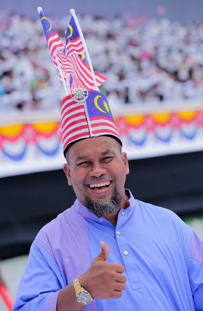 KUALA LUMPUR, MALAYSIA - AUGUST 31, 2016 : Man with Malaysia flag also known as Jalur Gemilang during Independence Day celebration or Merdeka Day at Merdeka Square.のeditorial素材
