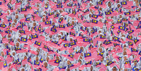 KUALA LUMPUR, MALAYSIA - AUGUST 31, 2016 : Student waving Malaysia flag also known as Jalur Gemilang during Independence Day celebration or Merdeka Day at Merdeka Square.のeditorial素材