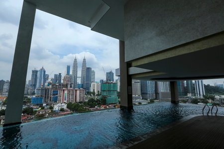KUALA LUMPUR, MALAYSIA - JULY 18, 2018 : Swimming pool with background view of Petronas Twin Tower and Kuala Lumpur city centre skyline.のeditorial素材