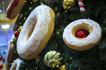Close up of Christmas tree decorations with ornaments of baubles, candy cane, sweet donut, and lights. Merry Christmas and Happy Holidays.の写真素材