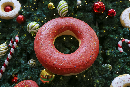 Close up of Christmas tree decorations with ornaments of baubles, candy cane, sweet donut, and lights. Merry Christmas and Happy Holidays.の写真素材