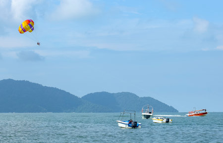 PENANG, MALAYSIA - NOVEMBER 24, 2018 : Parasailing activities at Batu Ferringhi Beach. Batu Ferringhi is one of Penang's most popular tourist attraction destinations.のeditorial素材