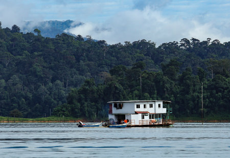 PERAK, MALAYSIA - JULY 11, 2018 : Cruising Houseboat for nature-lovers to discover peace environment of 130 million years old Royal Belum Rainforest Park acrossing Temenggor Lake.のeditorial素材