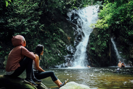 PERAK, MALAYSIA - JULY 11, 2018 : Tourist enjoying view of waterfall while discovering peace nature environment of 130 million years old Royal Belum Rainforest Park at Temengor Lake.のeditorial素材