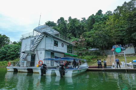 PERAK, MALAYSIA - JULY 11, 2018 : Cruising Houseboat for nature-lovers to discover peace environment of 130 million years old Royal Belum Rainforest Park acrossing Temenggor Lake.のeditorial素材