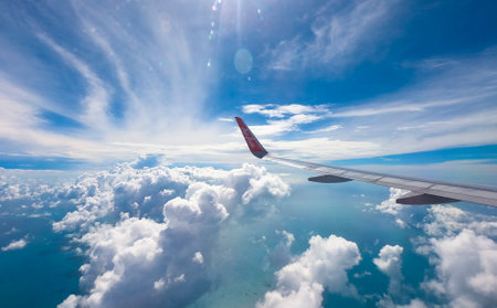 JAKARTA, INDONESIA - MARCH 25, 2019 : The wing of an Air Asia plane with its logo in blue sky background. AirAsia Low Cost Airlines operates scheduled domestic and international flights.のeditorial素材