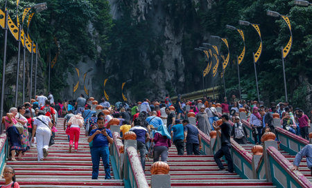 KUALA LUMPUR, MALAYSIA - OCTOBER 18, 2017 : Indian & tourist at entrance steps to Batu Caves temple in Kuala Lumpur. Batu Caves is a an iconic and popular tourist attraction in Malaysia.のeditorial素材
