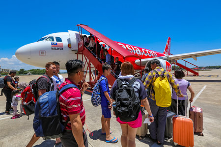 TERENGGANU, MALAYSIA - APRIL 18, 2019 : Tourist passengers is getting on a Air Asia Low Cost Airlines aircraft at Sultan Mahmud Airport. AirAsia operates scheduled domestic and international flights.のeditorial素材