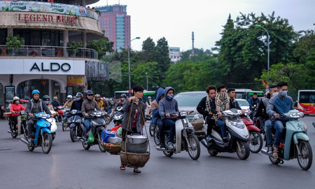 HANOI, VIETNAM - DECEMBER 11, 2014 : Vietnamese street market lady seller. They carrying a Òquang...