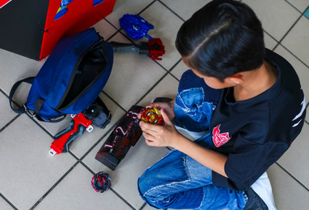 KUALA LUMPUR, MALAYSIA - OCTOBER 06, 2019 : Kids playing Beyblade toys. Beyblade is a line of...