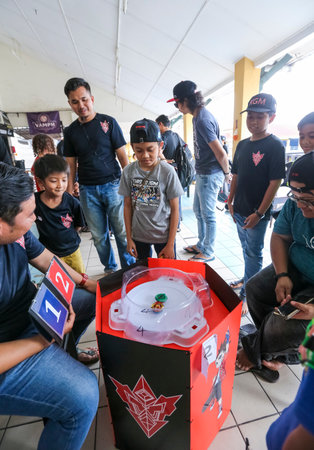 KUALA LUMPUR, MALAYSIA - OCTOBER 06, 2019 : Kids playing Beyblade toys. Beyblade is a line of...