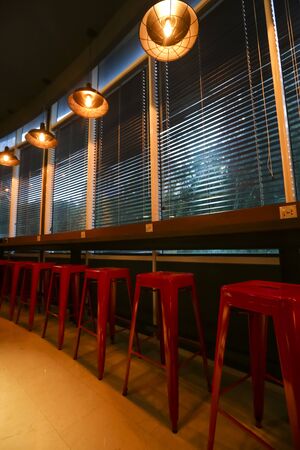 Row of chair / stools with ceiling lighting lamps interior decoration.の写真素材