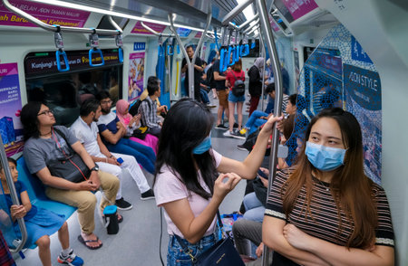 KUALA LUMPUR, MALAYSIA - FEBRUARY 22, 2020 : A woman wearing face mask to prevent infection of virus during commute Mass Rapid Transit (MRT). Coronavirus disease 2019 (COVID-19) outbreak.のeditorial素材