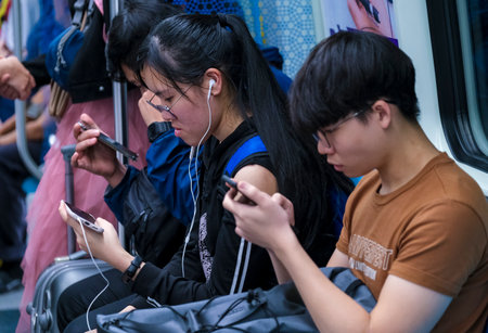 KUALA LUMPUR, MALAYSIA - FEBRUARY 22, 2020 : Passenger using mobile phone in Mass Rapid Transit (MRT) train to browsing web, listening music, playing games, texting and browsing social media.のeditorial素材