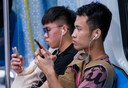 KUALA LUMPUR, MALAYSIA - FEBRUARY 22, 2020 : Passenger using mobile phone in Mass Rapid Transit...