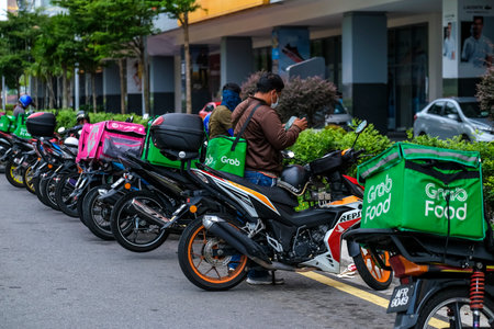 KUALA LUMPUR, MALAYSIA - MARCH 22, 2020 : Food delivery service rider for Foodpanda and GrabFood. Food delivery service through its mobile application.のeditorial素材