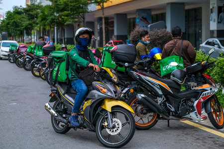 KUALA LUMPUR, MALAYSIA - MARCH 22, 2020 : Food delivery service rider for Foodpanda and GrabFood. Food delivery service through its mobile application.のeditorial素材