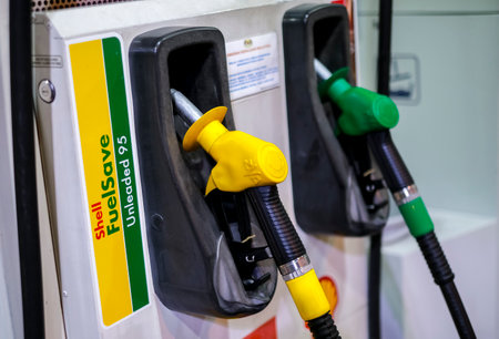 KUALA LUMPUR, MALAYSIA - MARCH 20, 2020: Petrol pump filling nozzles at Shell gas station. A filling station is a facility that sells gasoline, petrol and diesel fuel.のeditorial素材