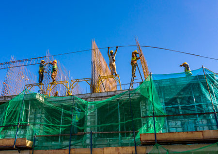 KUALA LUMPUR, MALAYSIA - MARCH 25, 2020: Construction workers work on high rise buildings at the construction site. Economy and development.のeditorial素材
