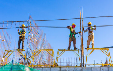 KUALA LUMPUR, MALAYSIA - MARCH 25, 2020: Construction workers work on high rise buildings at the construction site. Economy and development.のeditorial素材