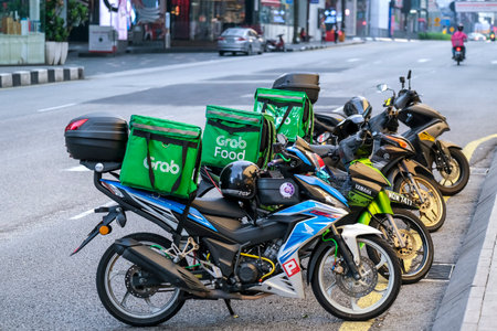 KUALA LUMPUR, MALAYSIA - APRIL 19, 2020: Food delivery service rider for GrabFood. Food delivery service through its mobile application.のeditorial素材
