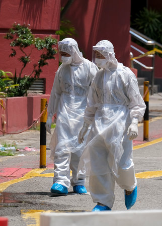 KUALA LUMPUR, MALAYSIA - APRIL 19, 2020: Health workers wearing a protective suit walk after entering COVID-19 red zone. Coronavirus disease 2019 (COVID-19) outbreak.のeditorial素材