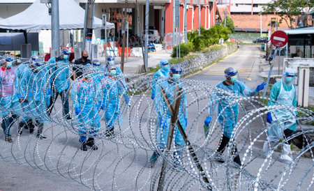 SELANGOR, MALAYSIA - MAY 12, 2020: A group of Police and local authorities wearing protective gear enter the locked down area in Petaling Jaya. Coronavirus disease 2019 (COVID-19) outbreak.のeditorial素材