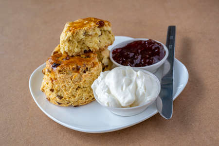 Scones with jam and cream on white plate. Delicious dessert.の写真素材