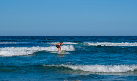 GOLD COAST, AUSTRALIA - APRIL 16, 2018: Surfers surfing and enjoying the glories weather at Main Beach, Surfers Paradise. One of the main tourist destination at Gold Coast.のeditorial素材
