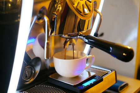 Close-up of espresso pouring from coffee machine at cafe. Professional barista coffee brewing.の写真素材