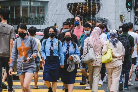 KUALA LUMPUR, MALAYSIA - MAY 27, 2022: A crowd of people wearing face masks walks along the famous district at Bukit Bintang or Star Hill. Tourist attraction place for shopping, eat and sightseeing.のeditorial素材