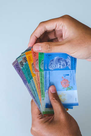 Selective focus at money with hand showing Malaysia banknotes, Ringgit Malaysia or Malaysia Ringgit...