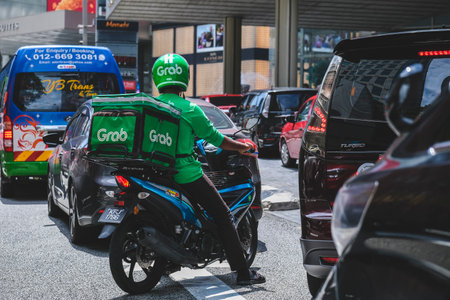 KUALA LUMPUR, MALAYSIA - SEPTEMBER 22, 2022: GrabFood rider. GrabFood is a food delivery service that connects local food businesses to people through its online mobile application.のeditorial素材