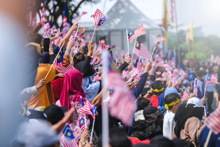 Malaysians waving the Malaysian flag is also known as Jalur Gemilang during the National Day celebration parade. Celebrating the independence or Merdeka Day.の写真素材
