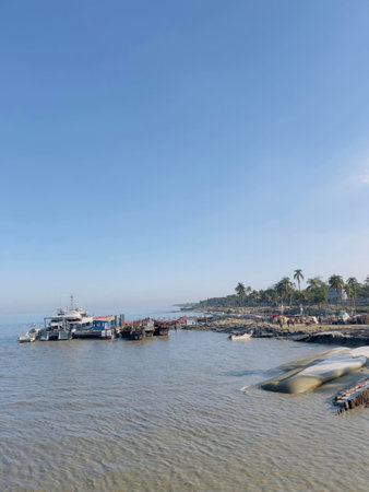 Calm coastal waterfront with boats under a clear blue skyの写真素材