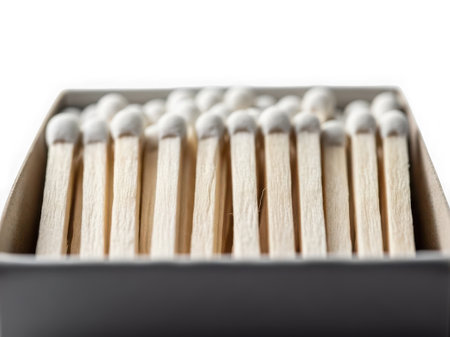 A closeup view of matchsticks neatly arranged in a cardboard box on a white backgroundの素材