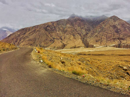 These massive mountains stands in way of clouds. The scene looked more amazing in real life. No wonder why riders take this road.のeditorial素材