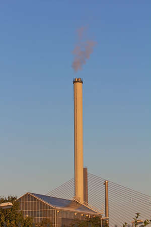 Smokestack in dawn with bridge in background
