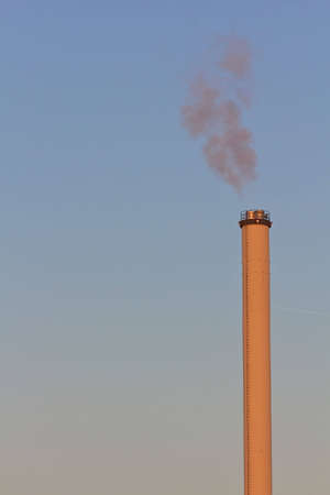 Smokestack in dawn with bridge in backgroundの写真素材