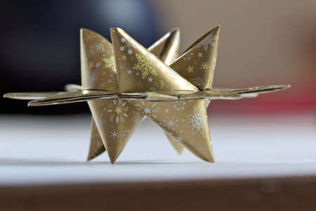 Christmas paper star folded with golden paperの写真素材