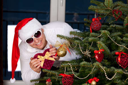 Santa Claus with a Christmas presents near christmas treeの写真素材