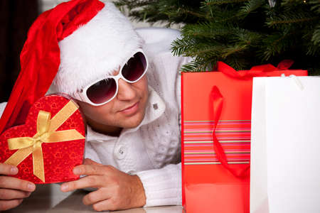 Santa Claus with a Christmas presents near christmas treeの写真素材