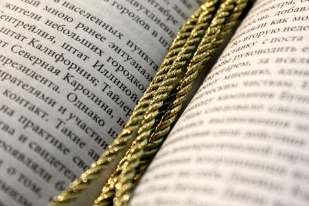The bookmark made of three golden ropes in the bookの写真素材