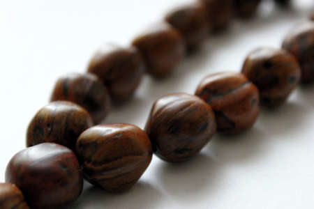 Rosary beads made of wood on a white backgroundの写真素材