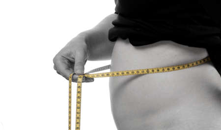 Young woman with a measuring tape, pregnantの写真素材