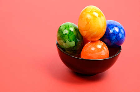 Colorful Easter eggs in a bowl with space for textの写真素材