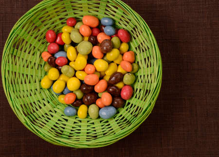 Sweet chocolate eggs in a green wooden bowlの写真素材